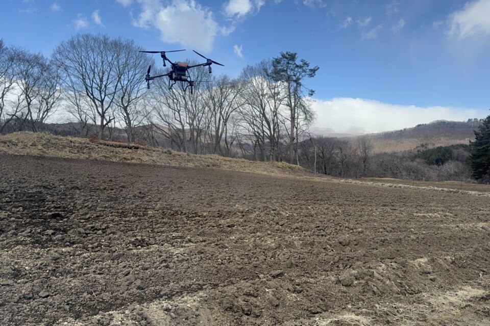 畑の上を飛ぶドローン